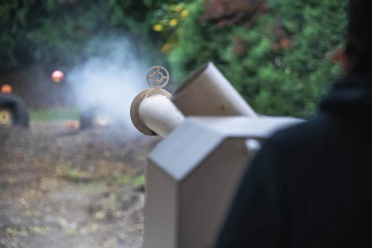 An apple leaving the barrel of the apple cannon in a puff of smoke